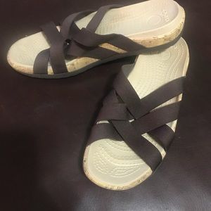 Brown CROCS sandals.